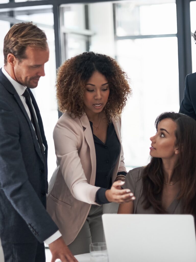 Cropped shot of a group of businesspeople using a laptop during a meeting in an office